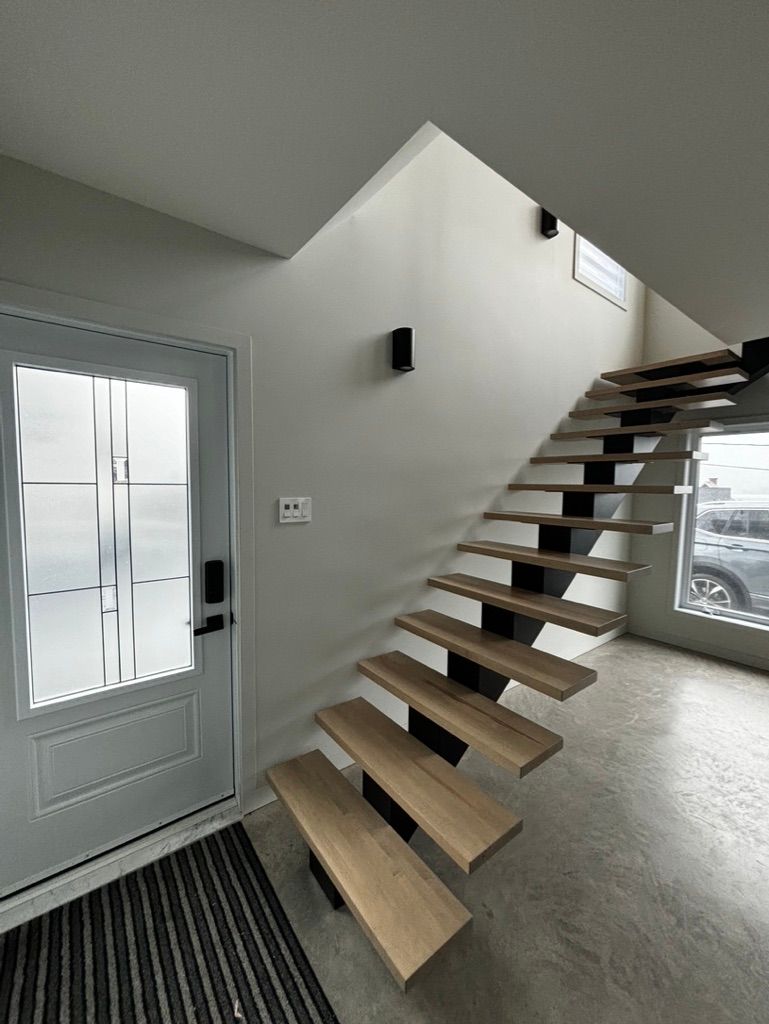 Un escalier en bois mène au deuxième étage d'une maison.