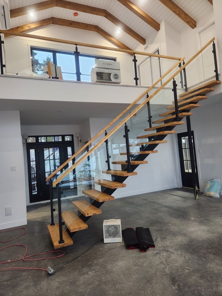 Un escalier en bois avec une rampe en verre dans une maison.