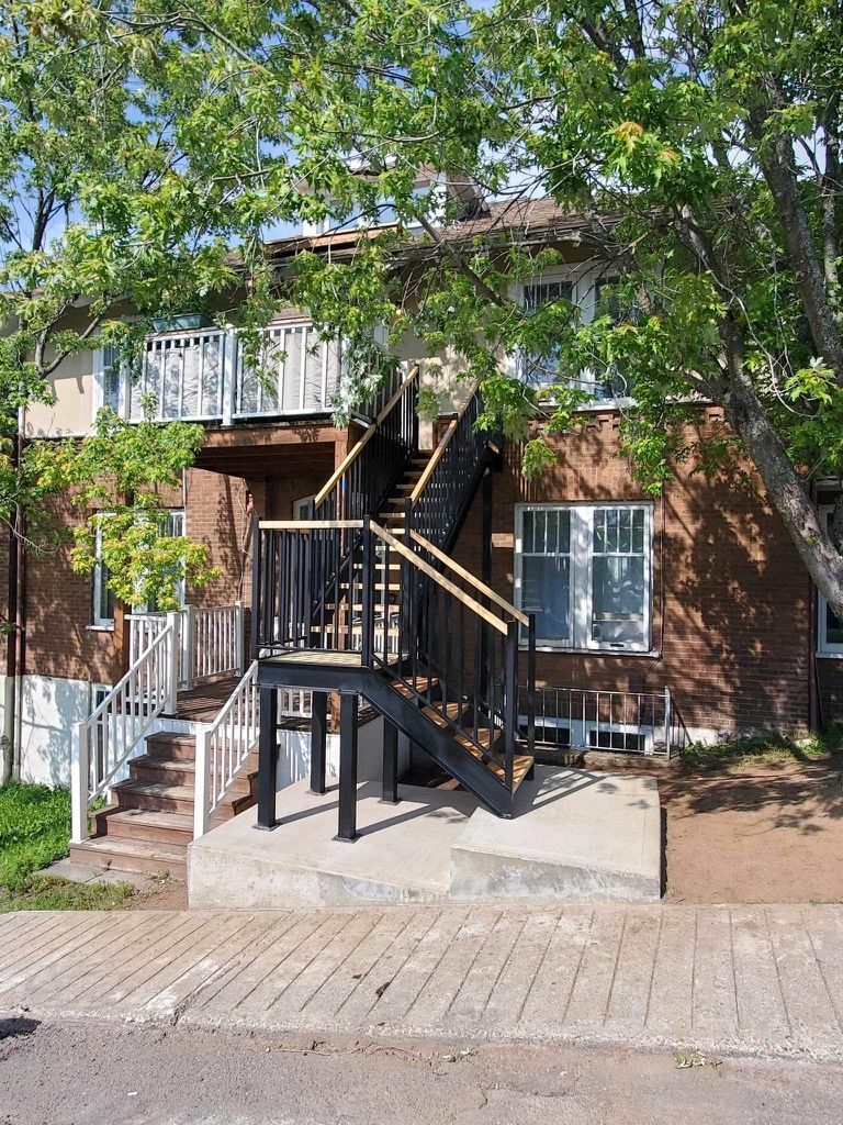 Une maison en briques avec des escaliers menant au deuxième étage