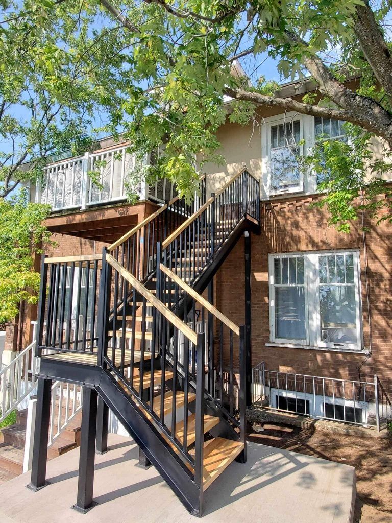 Une maison avec une terrasse et des escaliers qui y mènent.