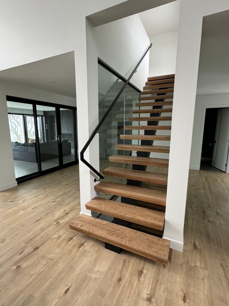 Un escalier en bois avec une rampe en verre dans une maison.