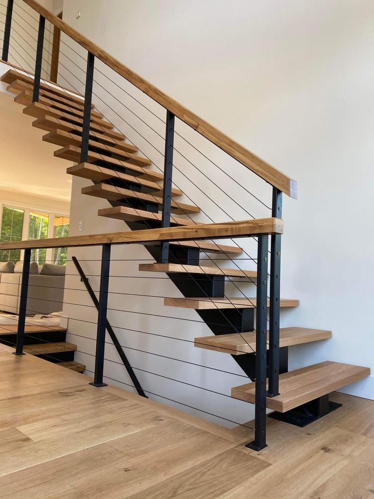 Un escalier en bois avec une rampe en métal dans un salon