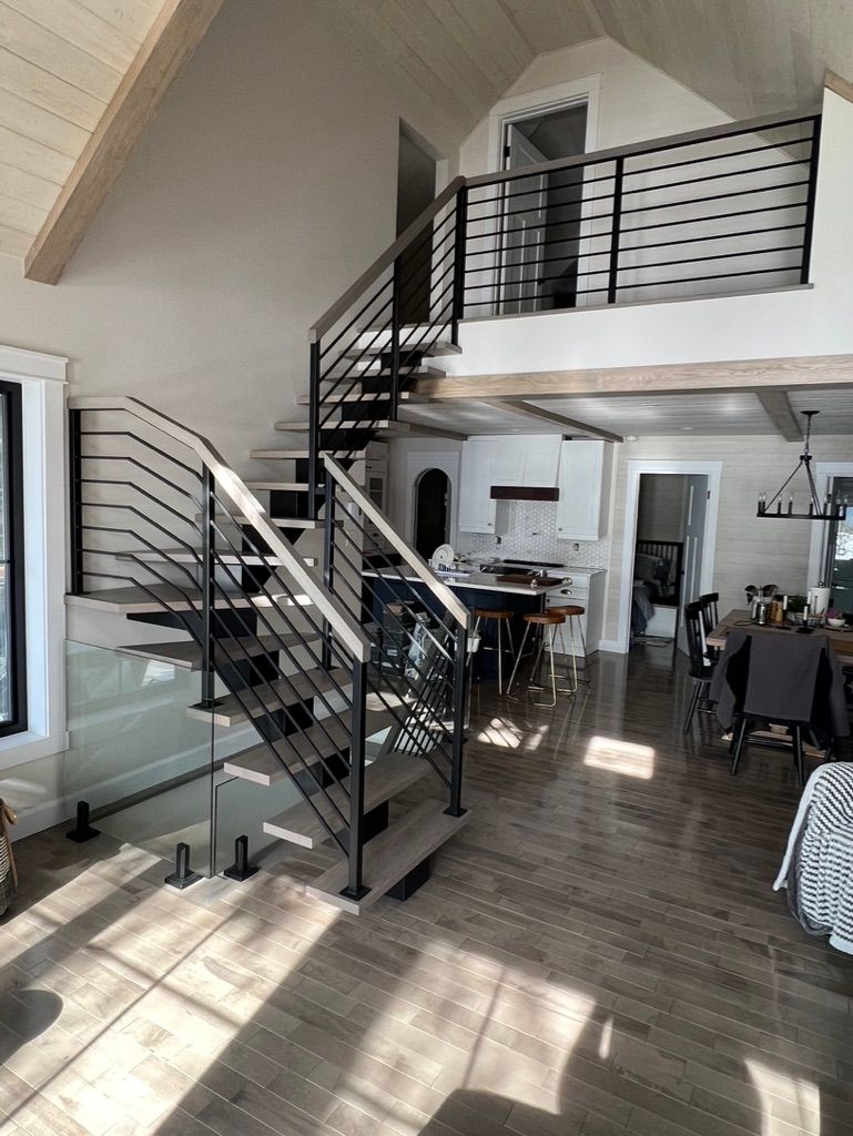 Un salon avec un escalier menant au deuxième étage.