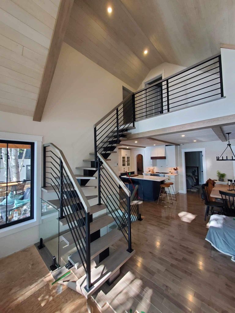 Un salon avec un escalier menant au deuxième étage.