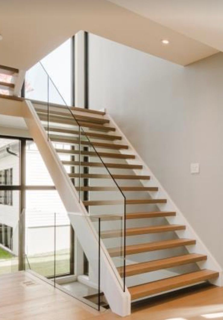 Un escalier avec des marches en bois et une rampe en verre