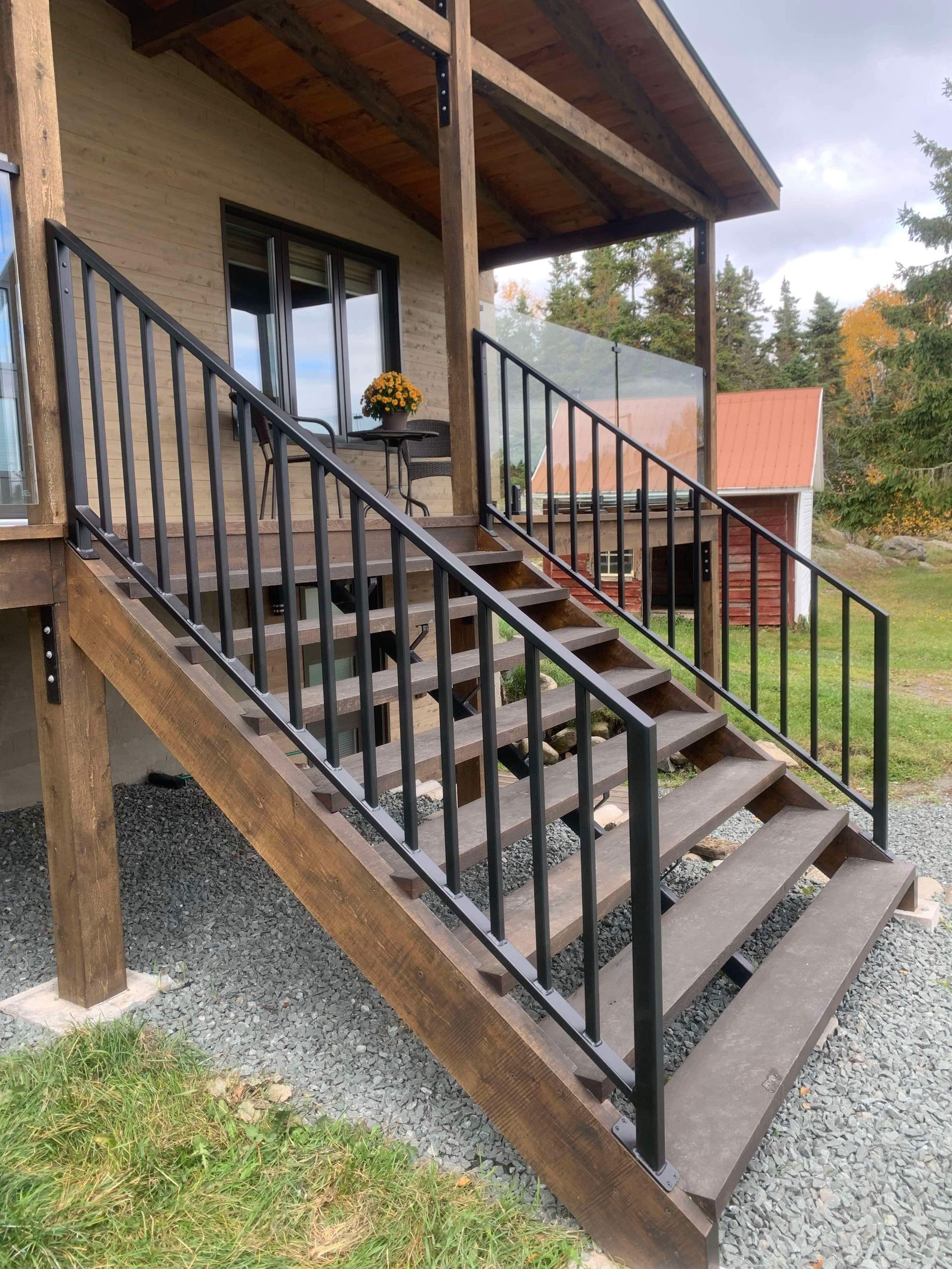 Un ensemble d'escaliers en bois menant à une maison avec une rampe en métal.