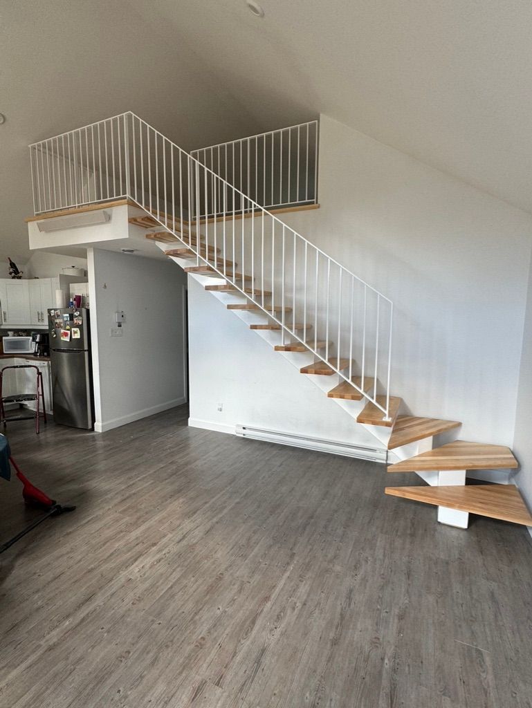 Un escalier en bois avec une rampe blanche dans un salon