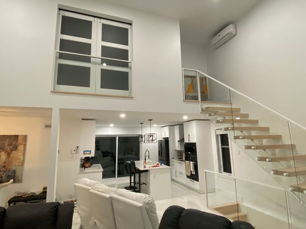 Un salon avec un escalier menant au deuxième étage.