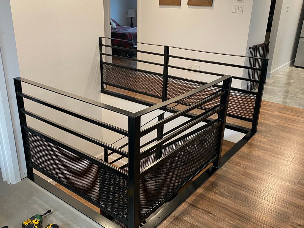 Un escalier avec une rampe en métal et un plancher en bois dans une maison.