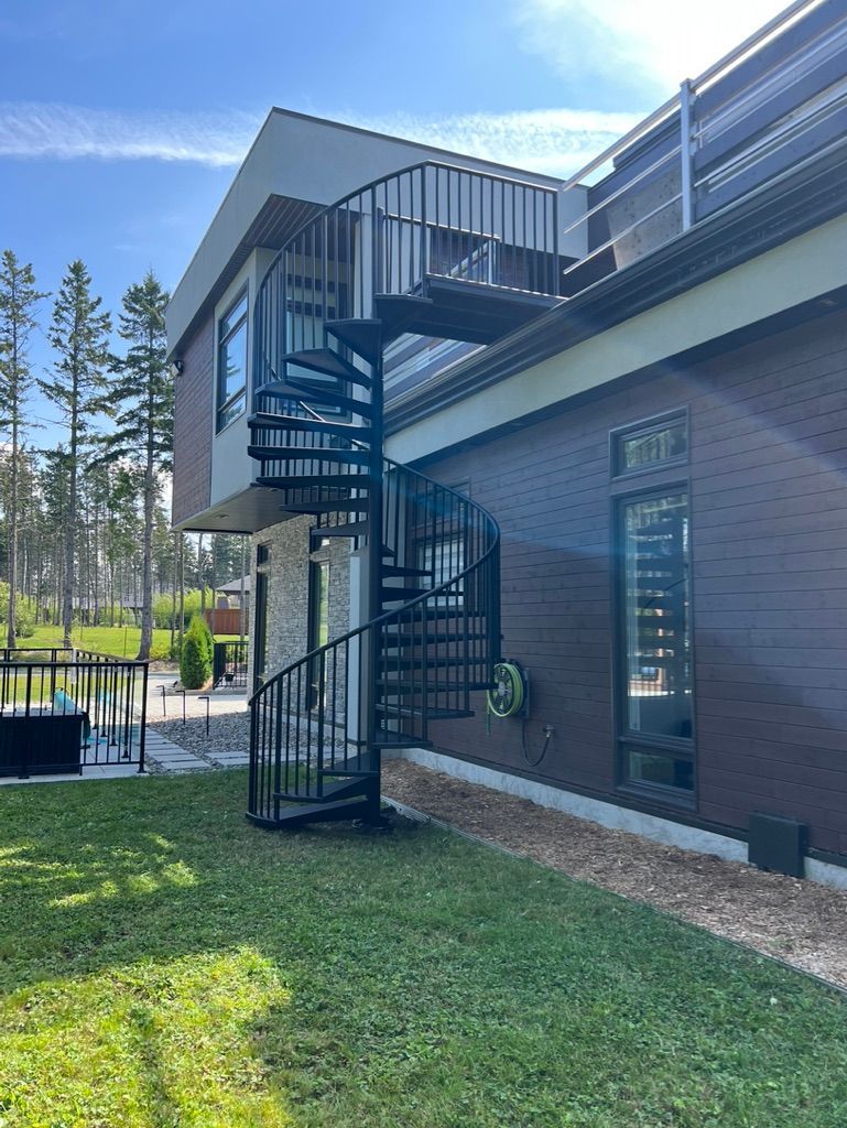 Un escalier en colimaçon est fixé sur le côté d'une maison.
