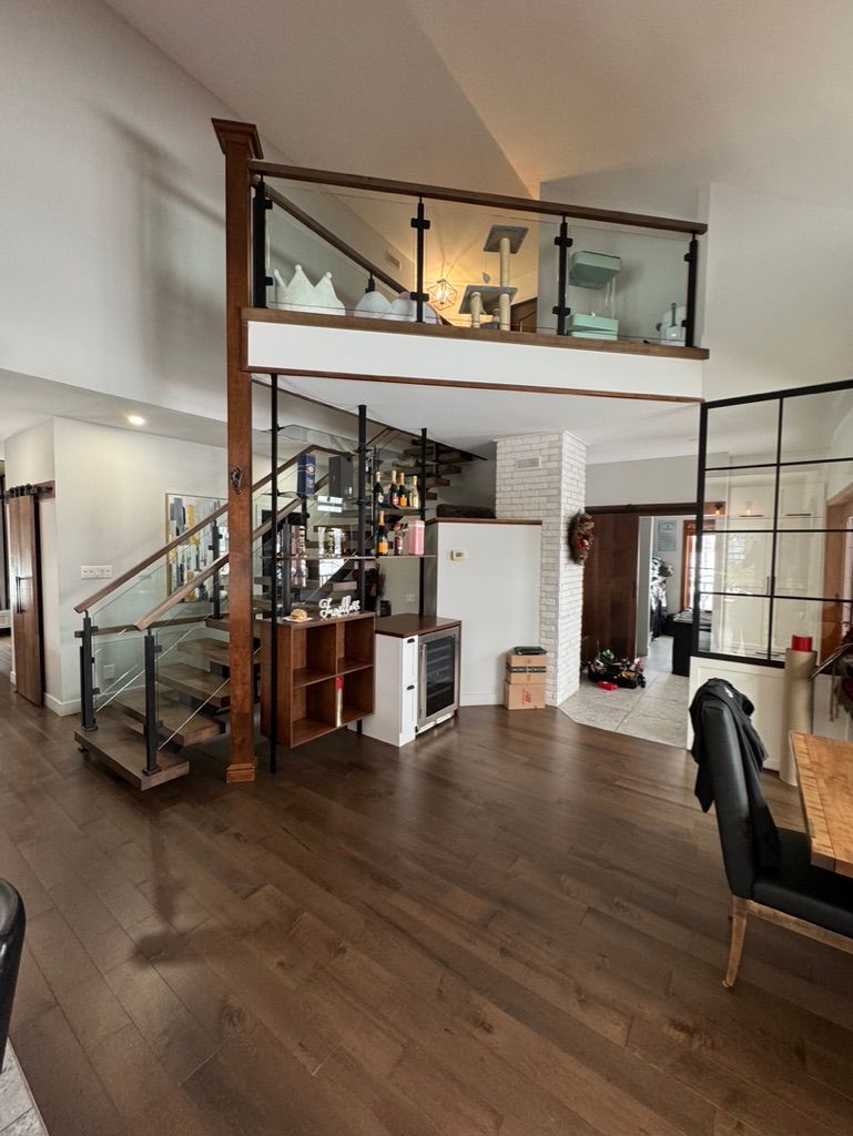 Un séjour avec un escalier et un balcon.