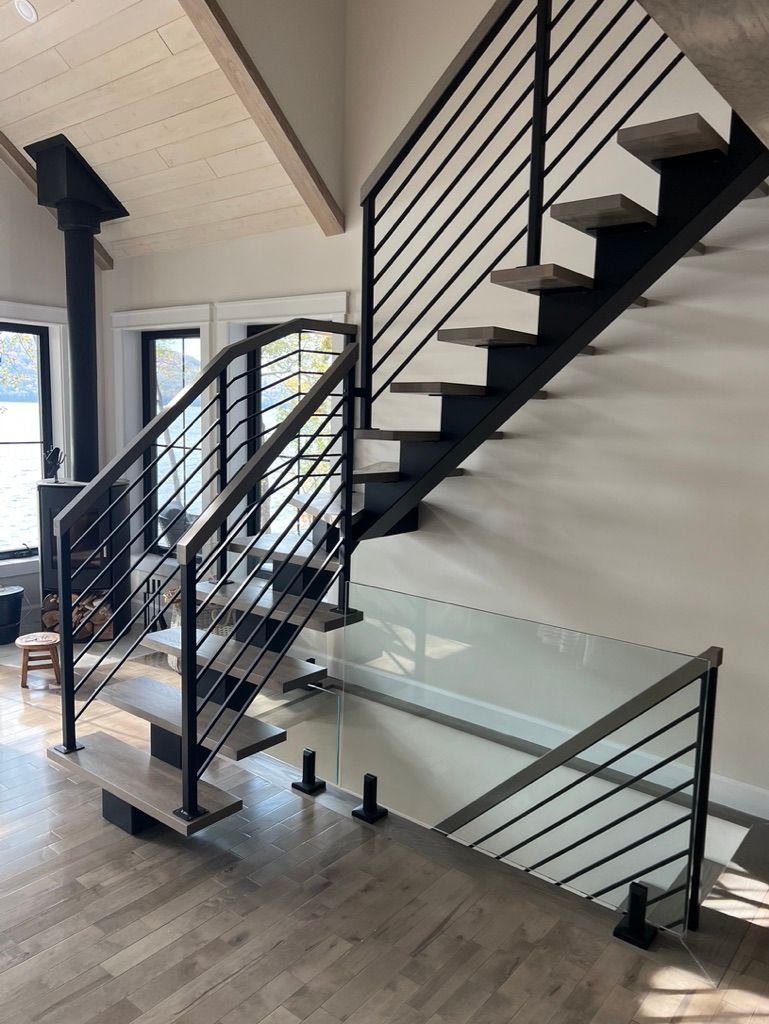 Un escalier avec une rampe en métal et une rampe en verre dans une maison.