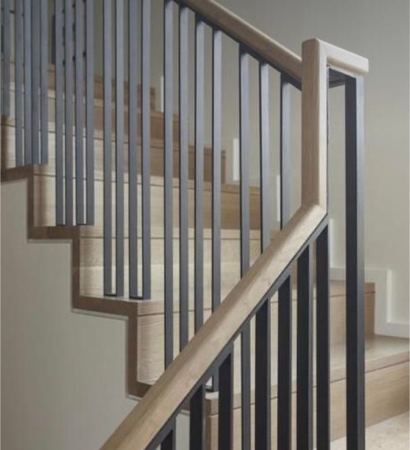 Un escalier avec une rampe en bois et une rampe en métal.