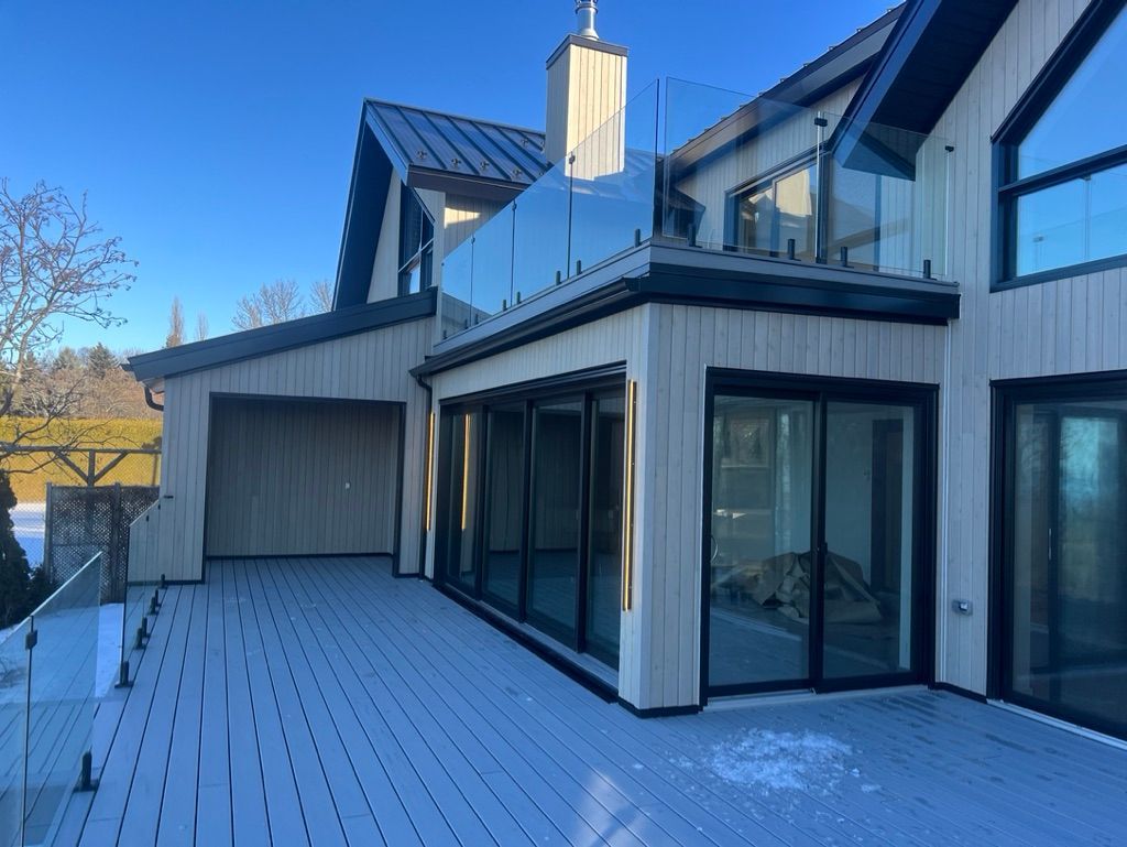 Une grande maison avec une grande terrasse et beaucoup de fenêtres.