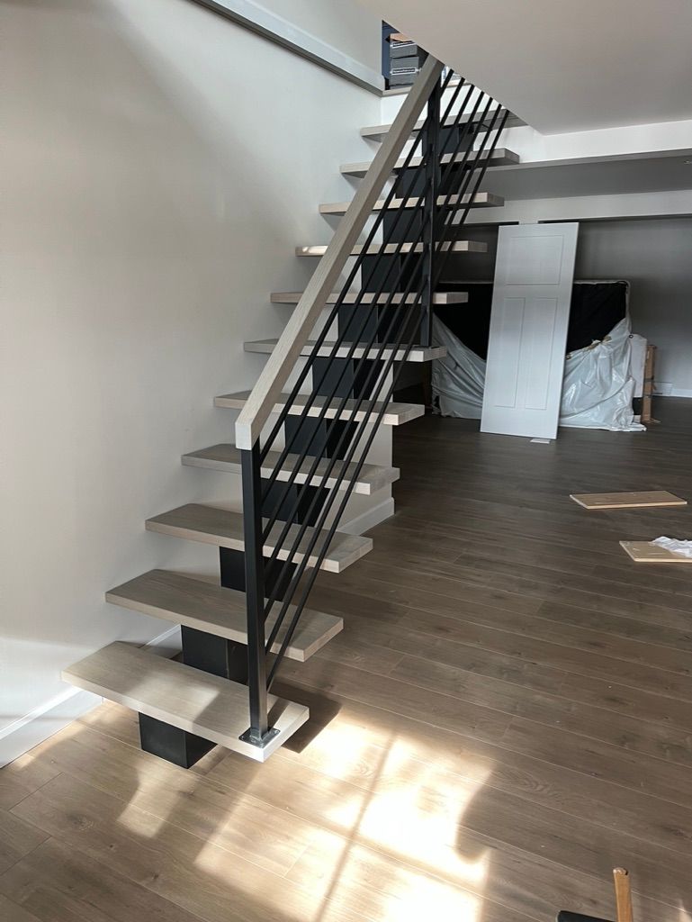 Un escalier en bois avec une rampe en métal dans une pièce.