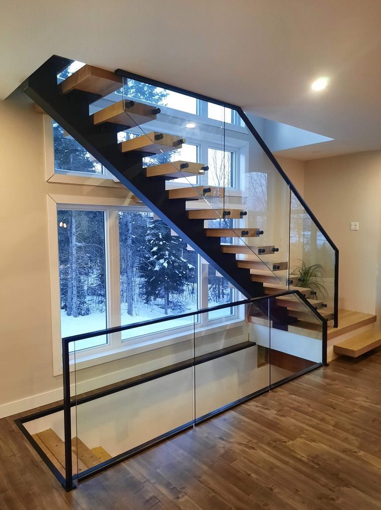 Un escalier avec des marches en bois et une rampe en verre
