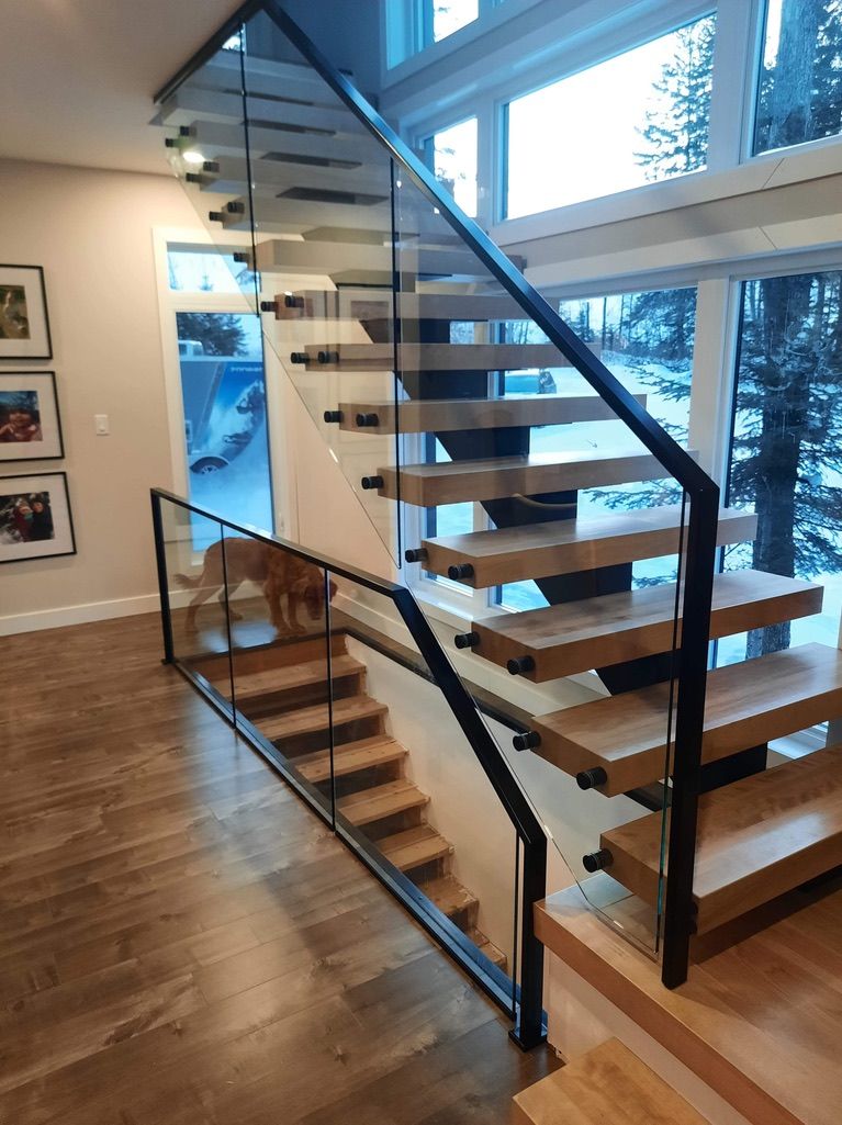 Un escalier en bois avec une rampe en verre dans une maison