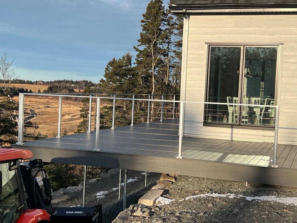 Un tracteur est garé devant une maison avec une terrasse.