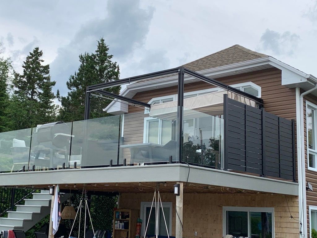 Une maison avec un balcon et des escaliers sur le côté.