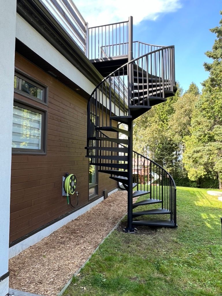 Un escalier en colimaçon se trouve sur le côté d'une maison.