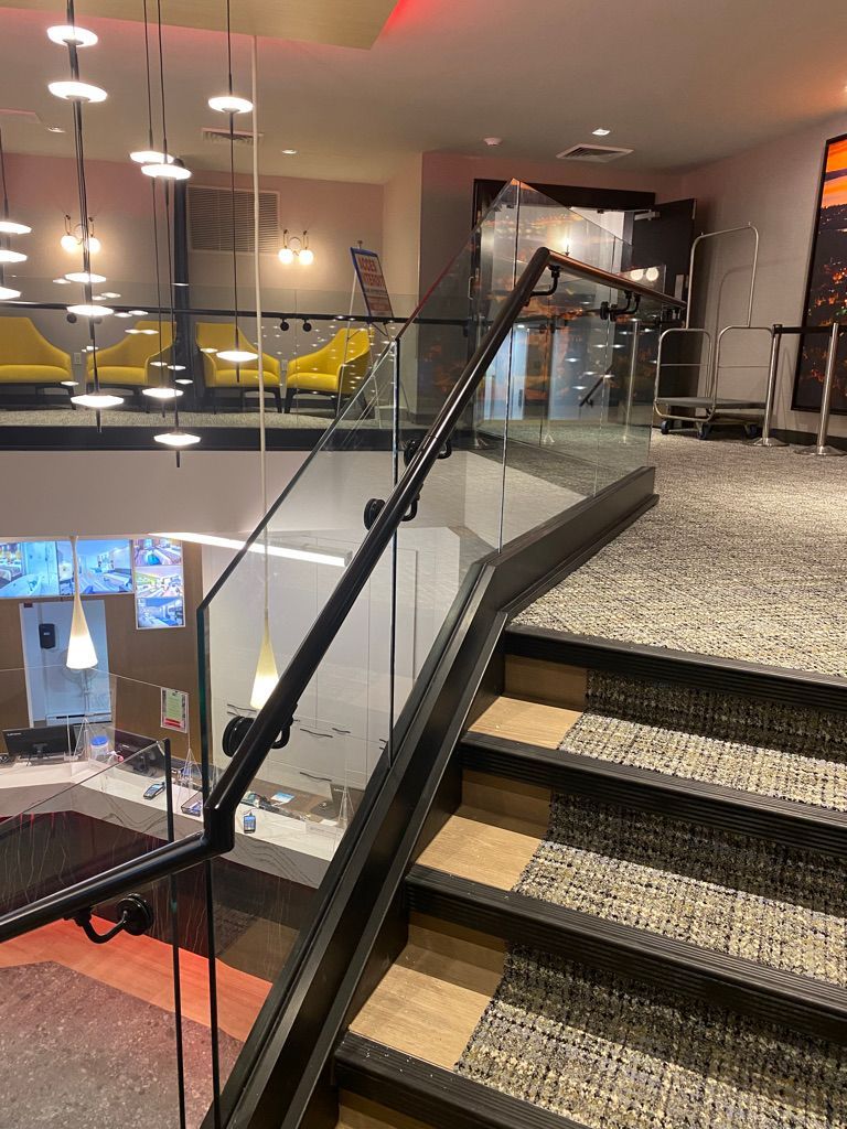 Un escalier avec une rampe en verre menant au deuxième étage d'un immeuble.