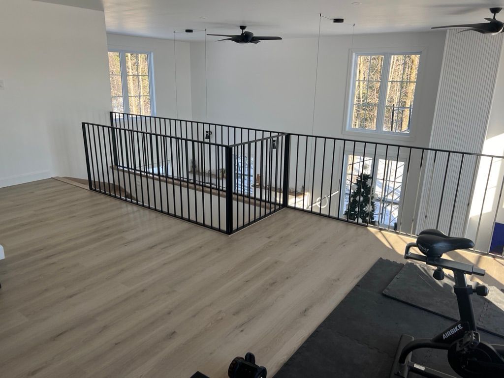 Une pièce vide avec une balustrade et un ventilateur de plafond