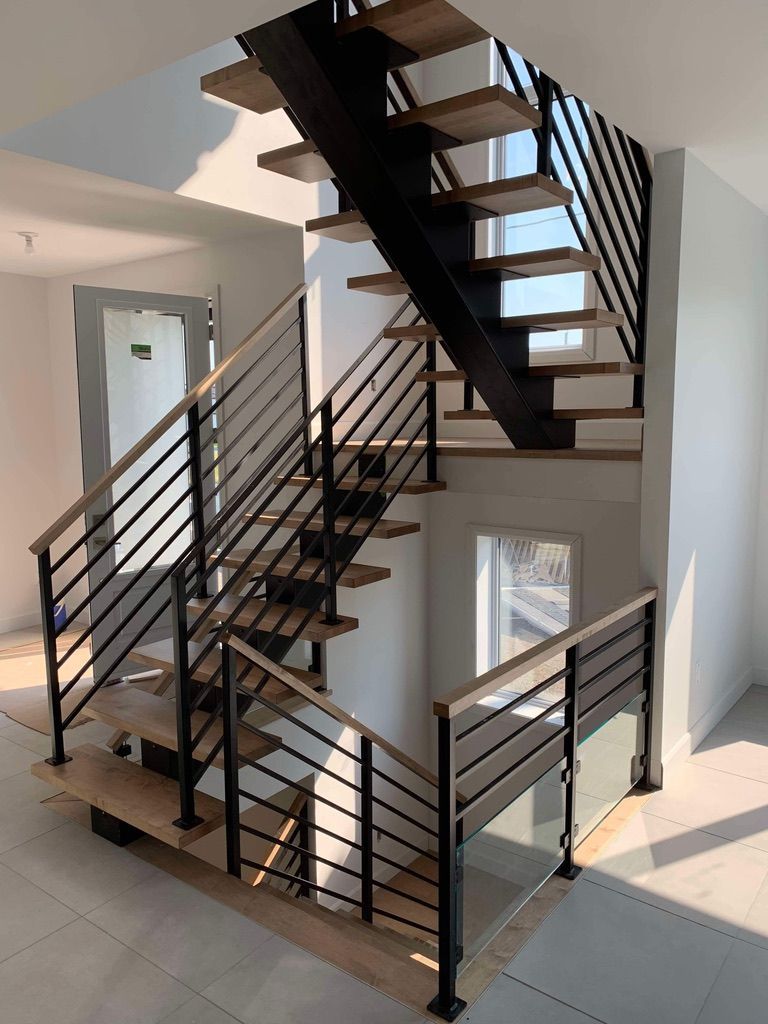 Un escalier avec des marches en bois et une rampe en métal dans une pièce.
