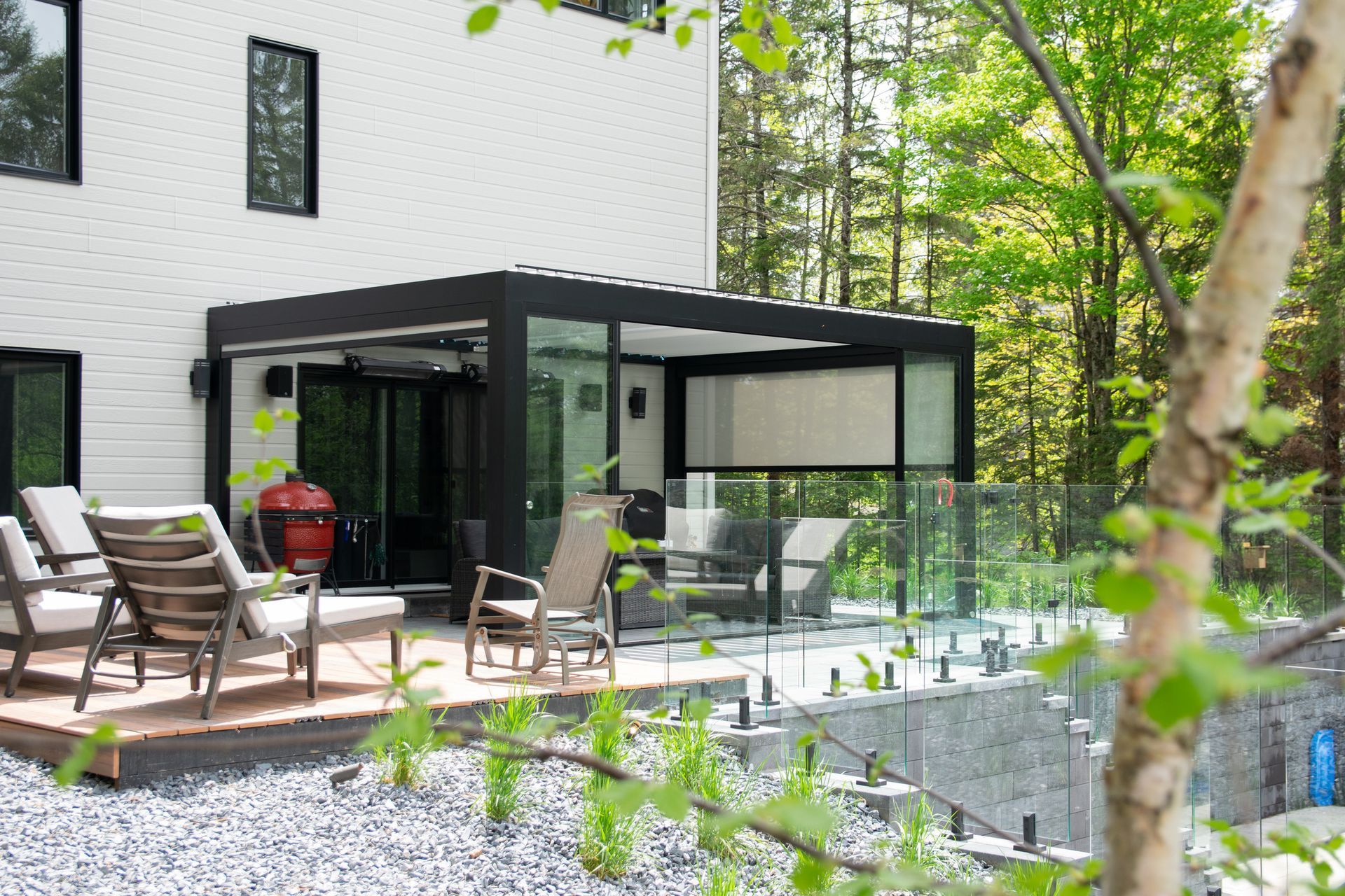 Un patio avec des chaises et un barbecue devant une maison.