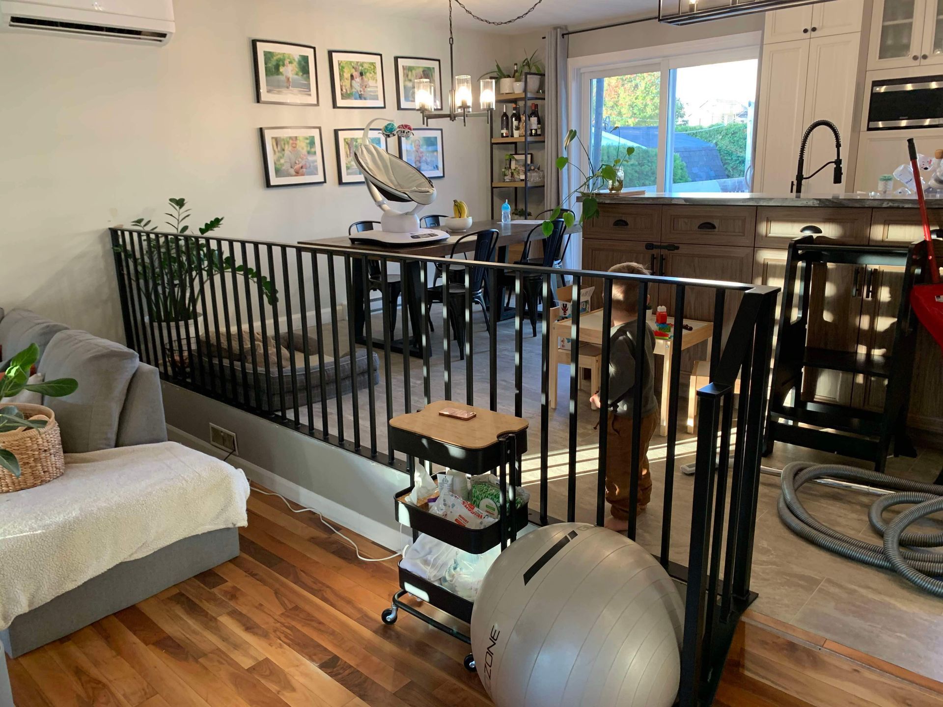 Un salon rempli de meubles et un escalier menant à une cuisine.