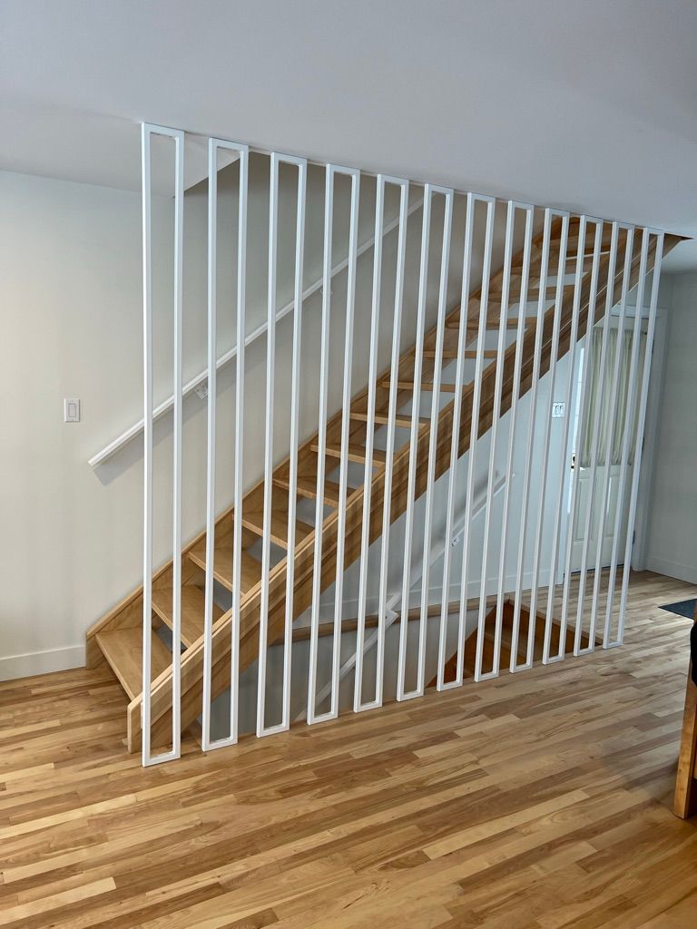 Un escalier en bois avec une rampe blanche dans un salon.
