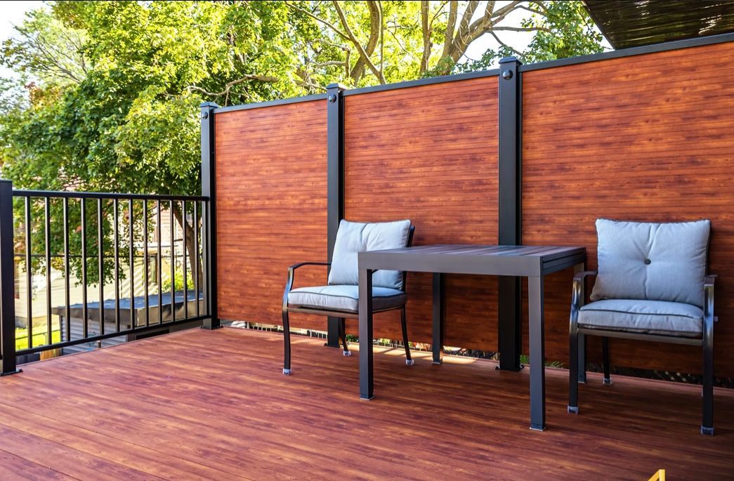Une terrasse en bois avec une table et des chaises devant une clôture en bois.