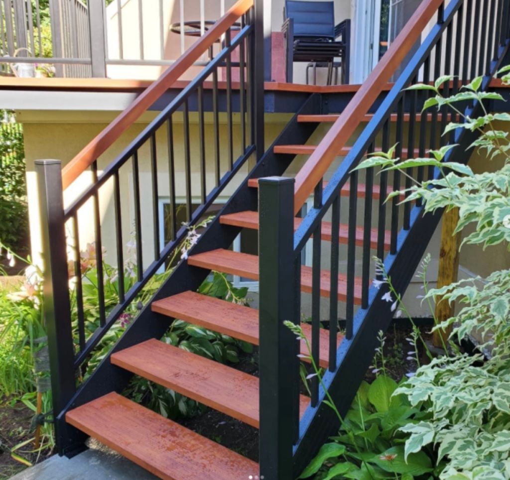 Un escalier en bois avec une rampe noire