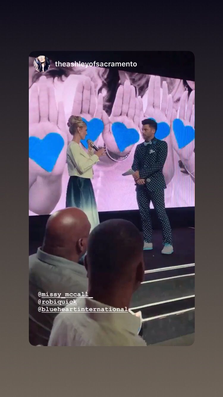 A man and a woman are standing on a stage talking to each other.