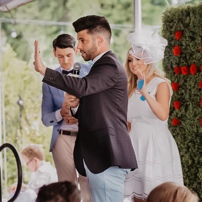 A man in a suit is giving a speech to a group of people