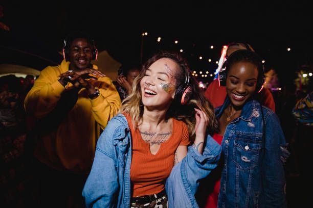 A group of people are dancing at a party while wearing headphones.