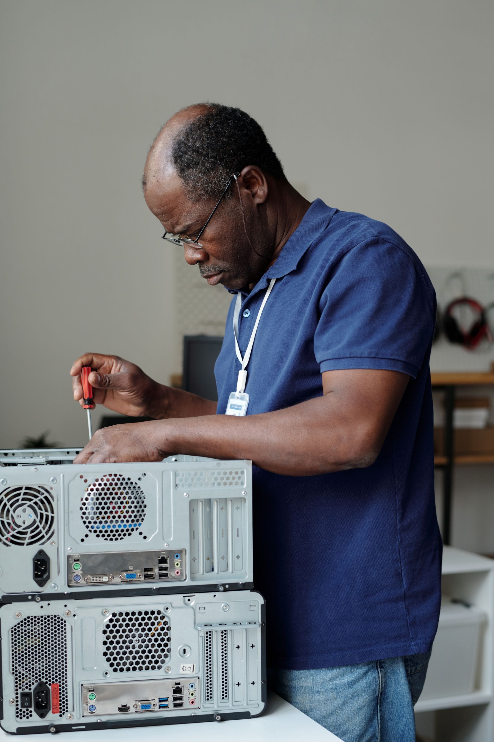 A man is working on a computer with a screwdriver.