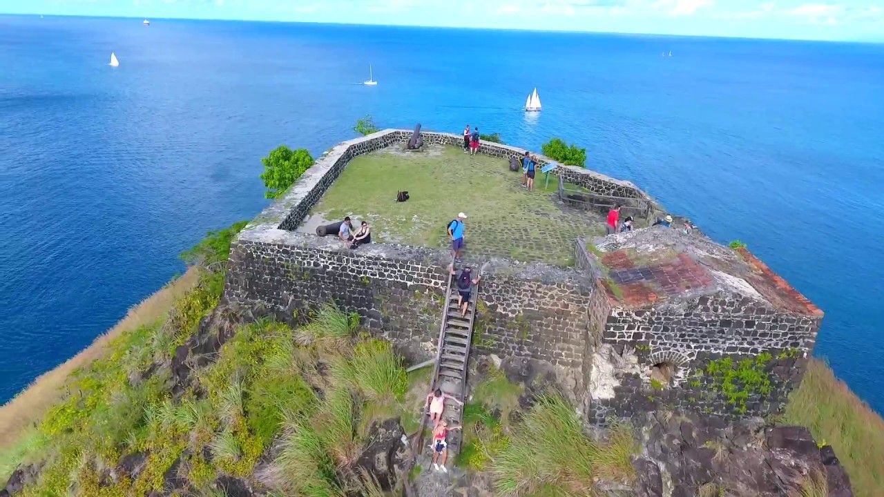 An aerial view of a castle on top of a hill overlooking the ocean.