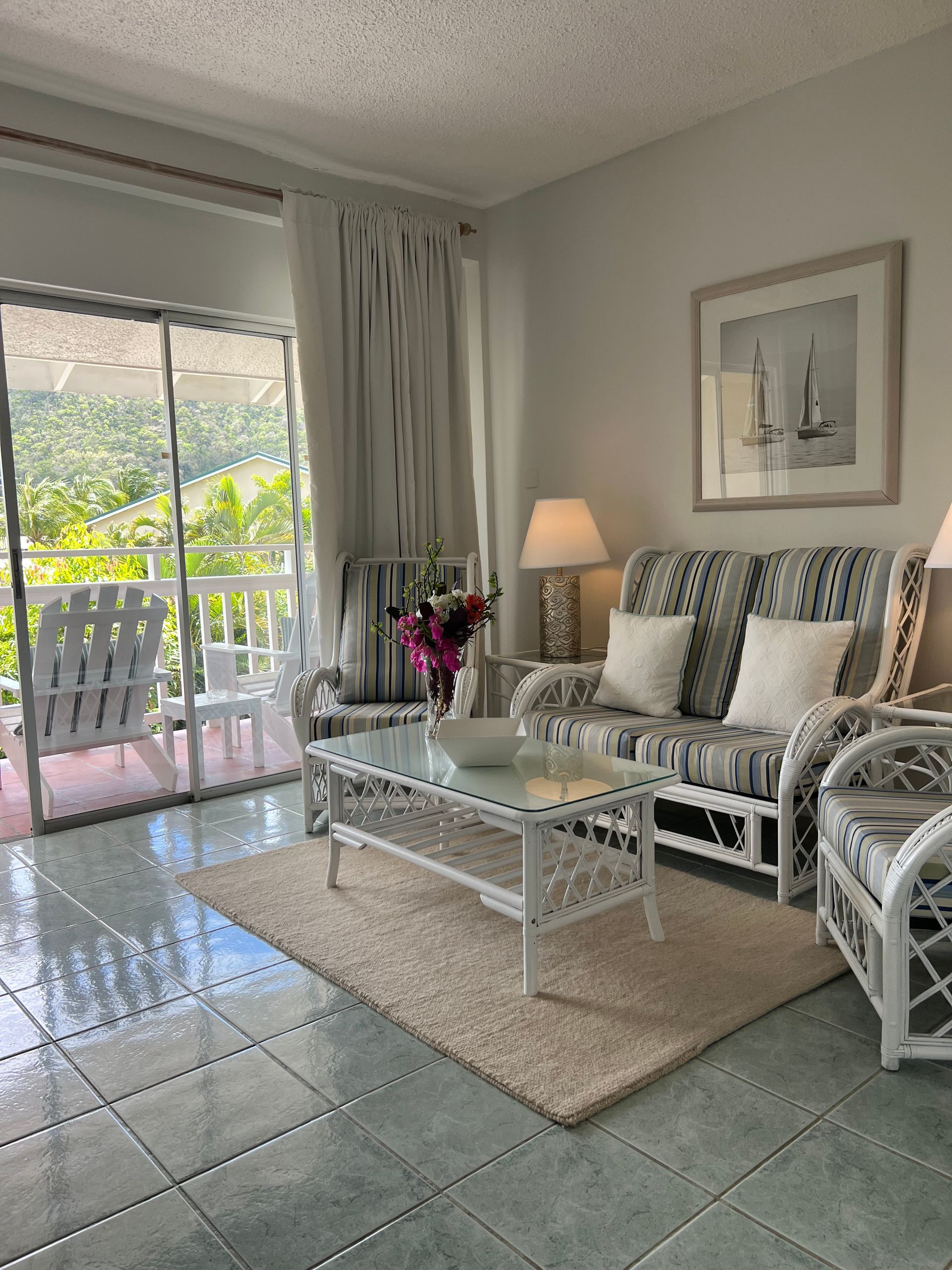 A living room with a couch , chairs , coffee table and sliding glass doors.