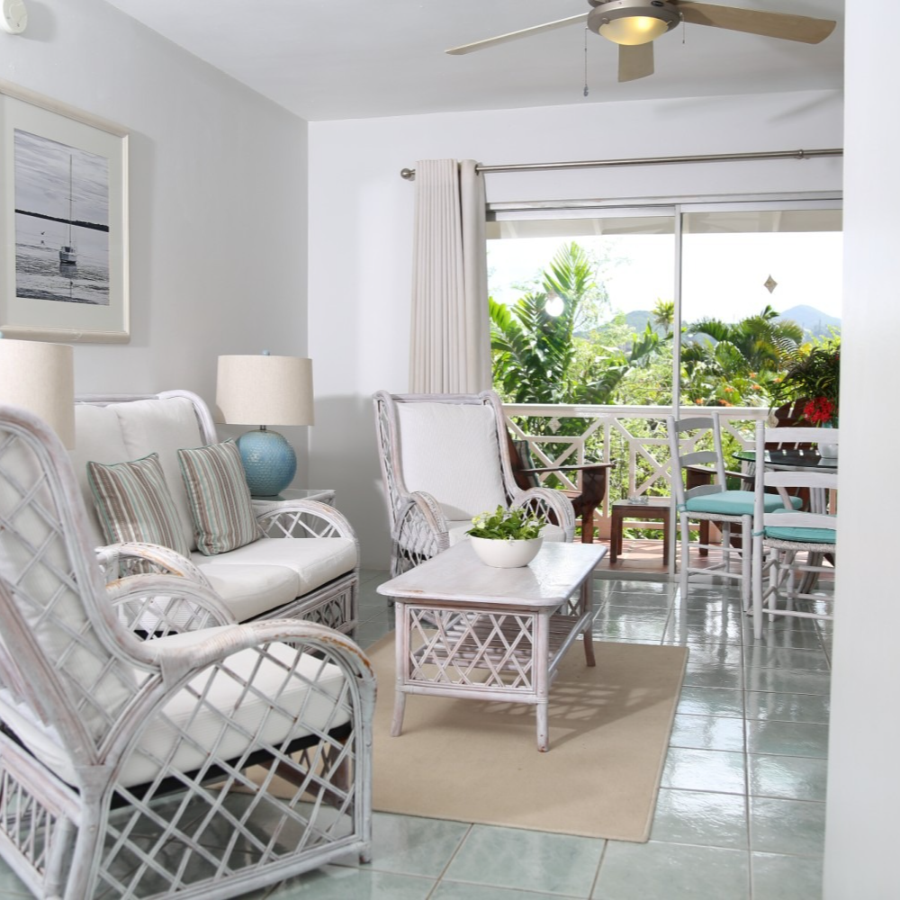 A living room with white furniture and a ceiling fan