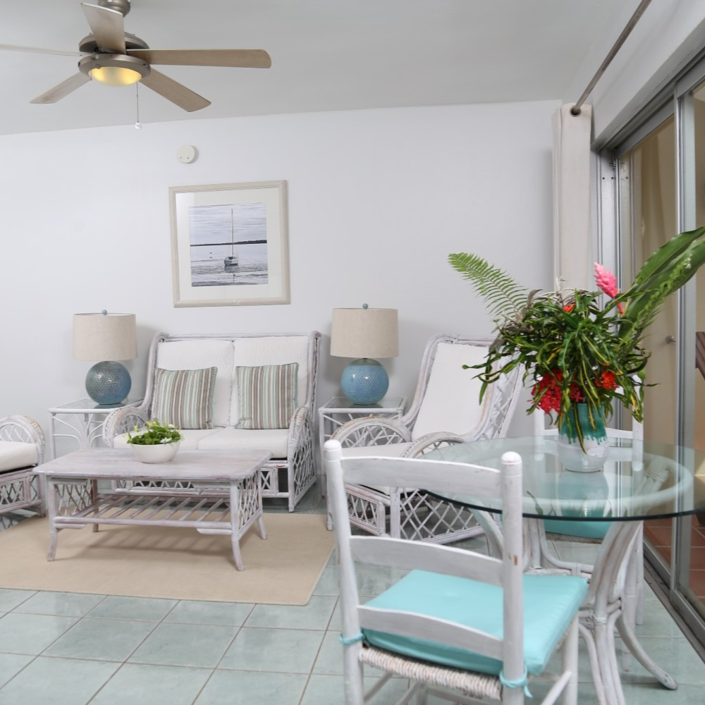 A living room with a table and chairs and a ceiling fan
