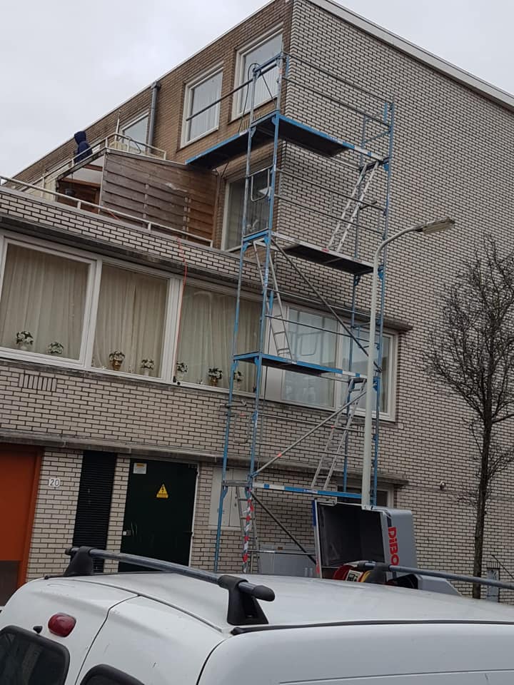 Een rolsteiger in gebruik in een woonwijk