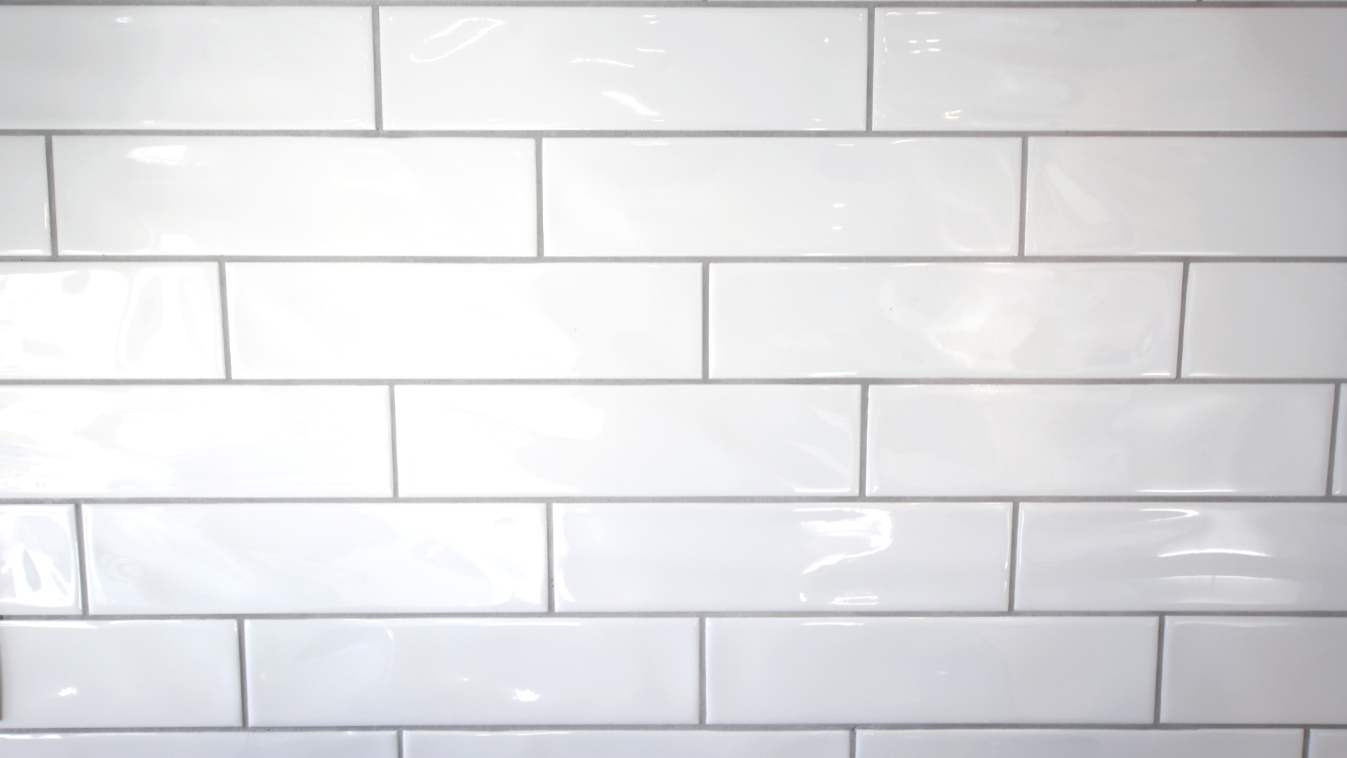 A close up of a white subway tile wall.