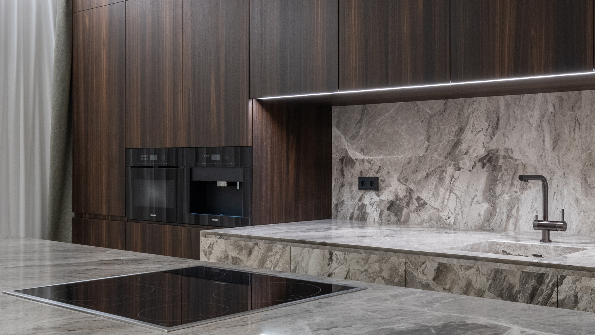 A kitchen with a stove top oven , sink , and microwave.