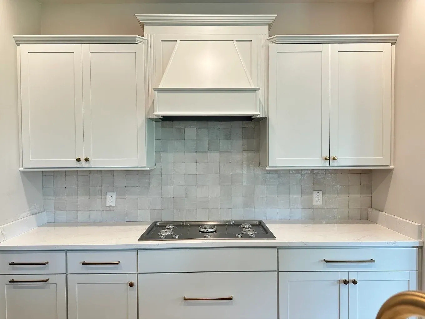A kitchen with white cabinets and a stove top oven.