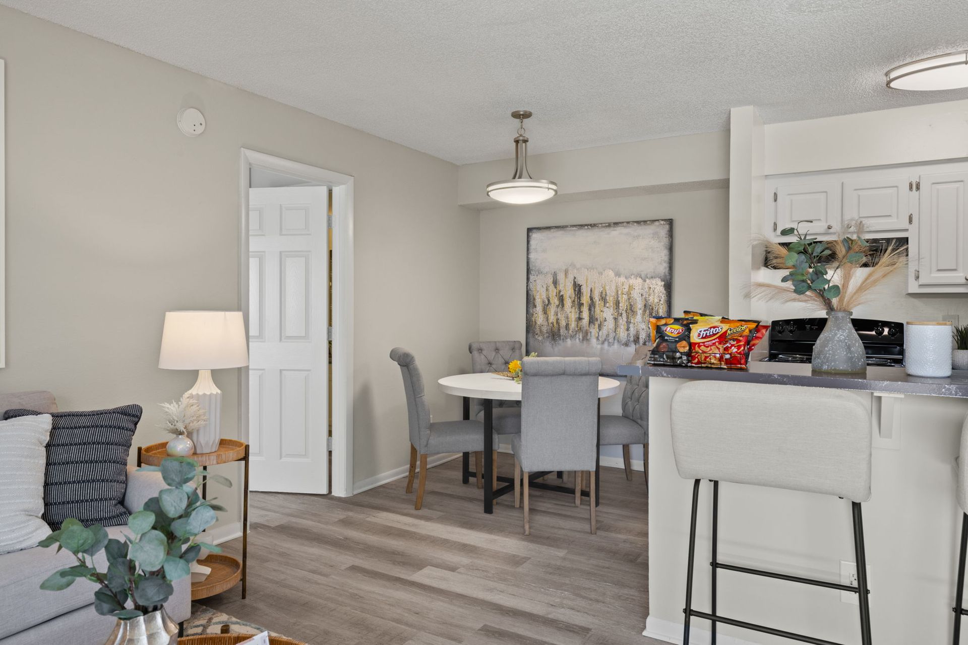 Interior view: Living room with dining area and open kitchen. Neutral color scheme, grey floors, and a modern aesthetic.