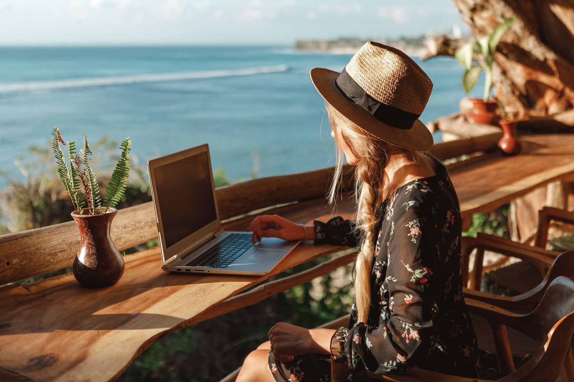 Woman sitting at a table looking at her laptop
