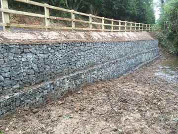 a retaining wall and wooden fence