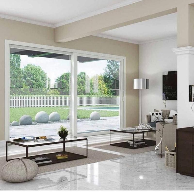 Soggiorno moderno con porte scorrevoli in vetro, vista sul giardino e arredamento minimalista.