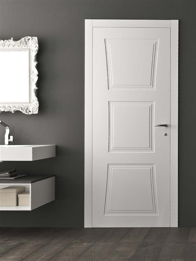 Porta bianca a tre pannelli in un bagno con lavandino e specchio su una parete grigio scuro.