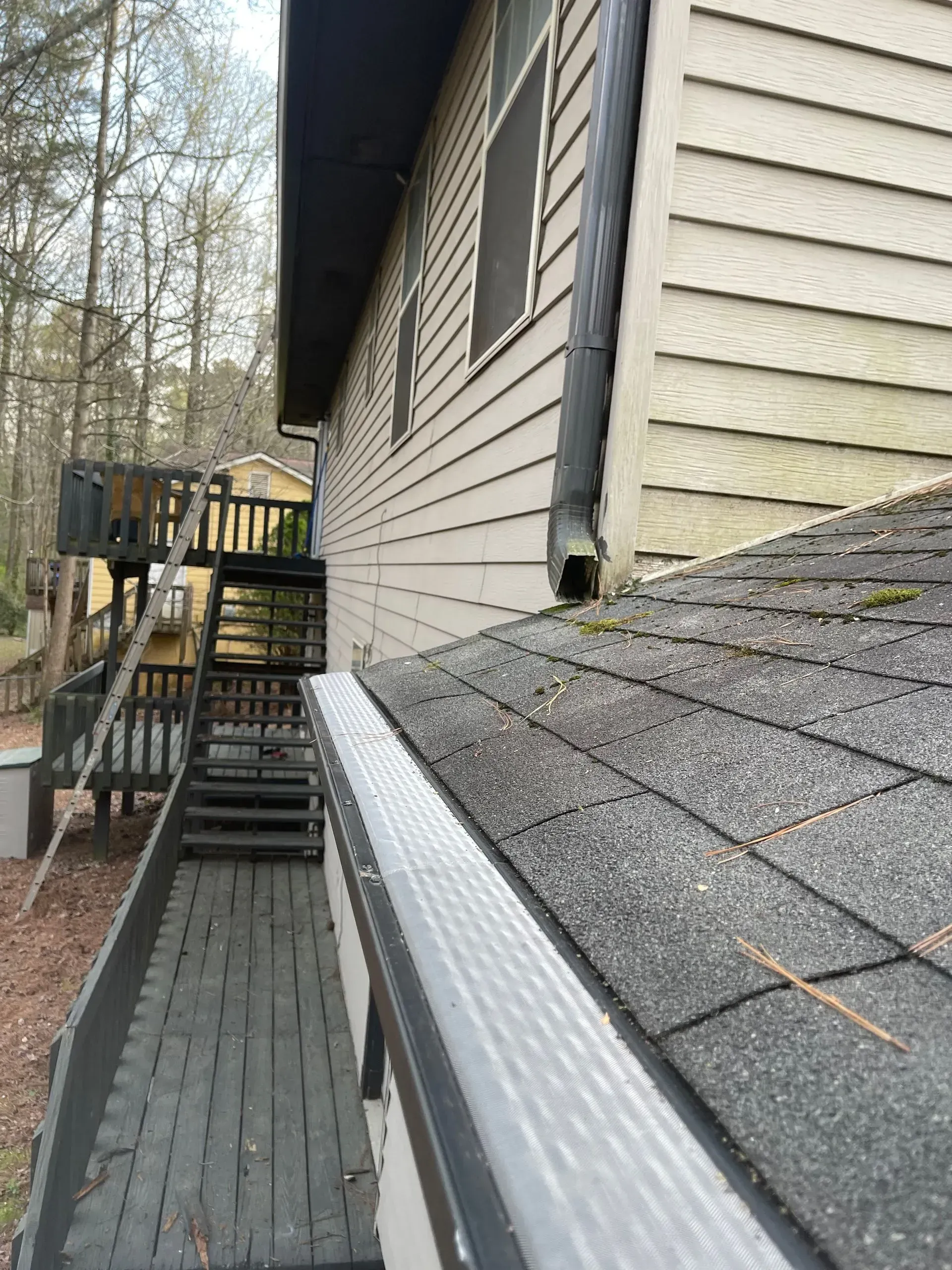 A house with stairs and a gutter on the side of it.